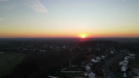 Drone footage of a slow falling sunset over a quiet suburban neighborhood in Stock Footage 228699085