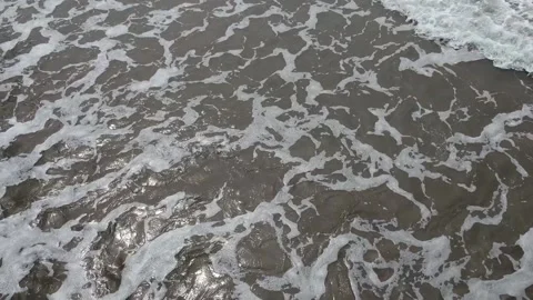 Drone footage of small waves on a beach. Diagonal waves rolling in. Stock Footage 228629661