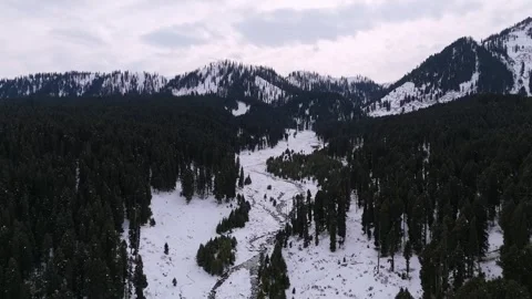 Drone footage of a stream gently splitting the snow-covered valley in Stock Footage 311794035