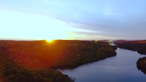 Drone footage of the sun setting over a peaceful lake during the fall - 4k Stock Footage 70344231