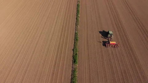 Drone footage of a tractor performing seeding operations in agricultural Stockbeeldmateriaal 333295405