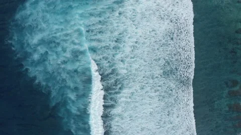 Drone footage of transparent clear blue waves of the sea, slow motion, Aerial Stock Footage