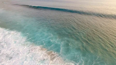 Drone footage of turquoise blue waves crashing over shallow reef in Indonesia Stock Footage 93781403