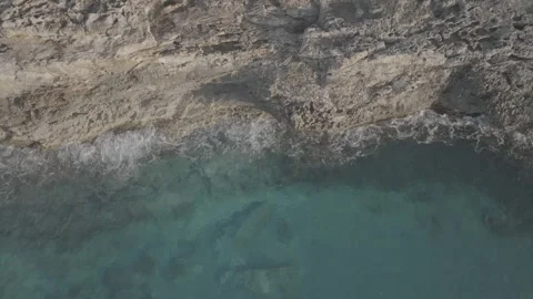 Drone footage of waves breaking on the cliffs in Menorca, Balearic Island - DLog Stock Footage 246489204