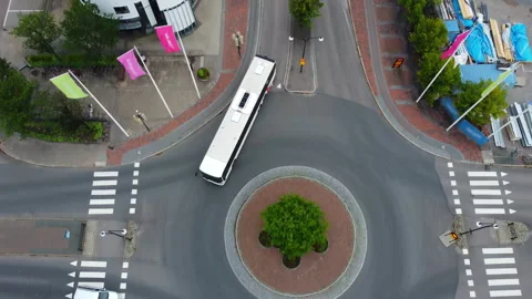 Drone Footage of White Bus Driving Into Roundabout Stockbeeldmateriaal 294150136