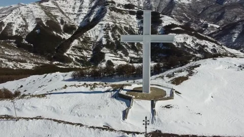 Drone footage of a white cross on the top of a snowy mountain in Korca, Albania  Stock Footage