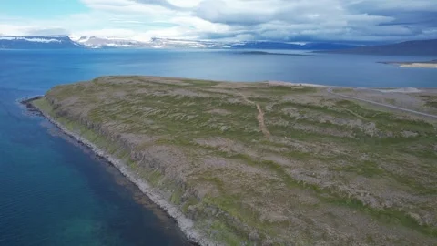 Drone forward and rotate over green headland and fjord coast, Sudavik Stock Footage 346552412
