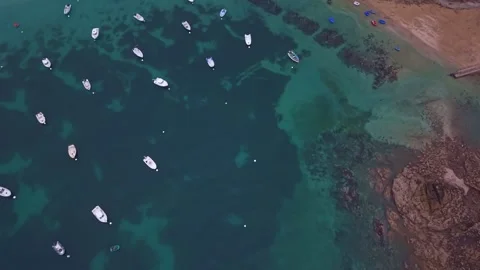 Drone forward flyover above anchored boats and rocky shoreline on the Emerald Stock Footage 342073749
