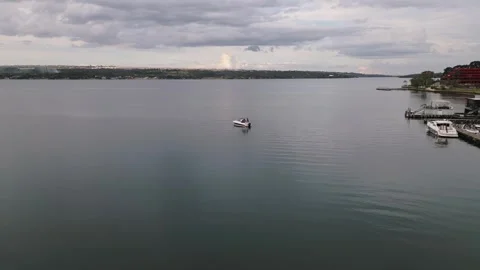 Drone forward flyover across Lake Paranoa with boats and lakeside marina in Stock Footage 342574203