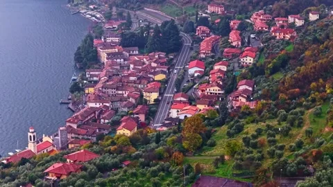 Drone Forward Over Lago d'Iseo Lakeside Village Red Rooftops and Autumn Hills Vídeos de archivo 336709121