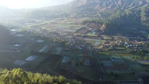 Drone Forward Over Mountain Valley and Farmland at Sunrise, Indonesia Video stock 333610375