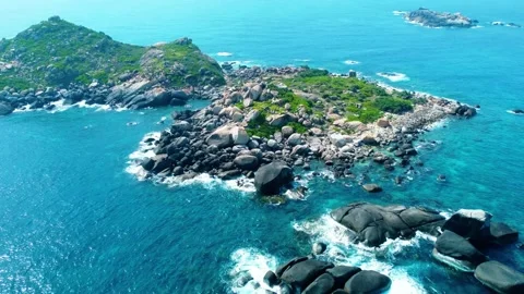 Drone forward push shot over an untouched rocky beach and blue sea 4K Stock Footage 339378354