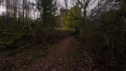 Drone FPV view of approach through forest to abandoned Lennox Castle in Scotland Stock Footage 308788367