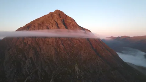 Drone of Glencoe, Scotland with low clouds at sunrise Stock Footage 254710324
