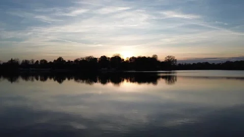 Drone glide over lake with swan at sunset, rising aerial shot Video stock 331813360