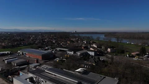Drone glide over san nazzaro d'ongina pc italy showing industrial area river Vidéo 334404584