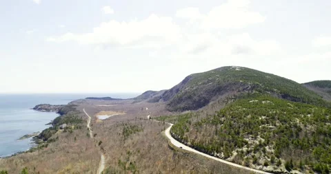 The drone glides above the dramatic Atlantic edge of Acadia with forests and Stock Footage 342106011