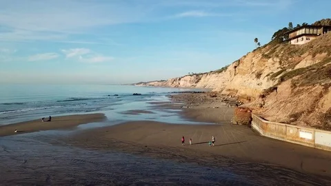 Drone glides forward at 20 feet over beautiful cliff-side beach Stock Footage 85453290