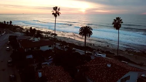 Drone glides forward at 40 feet over oceanfront homes at sunset Stock Footage 84949898