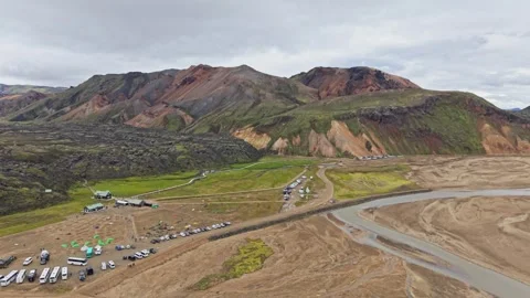 Drone glides forward over Landmannalaugar’s campsite and river Stock Footage 324967352