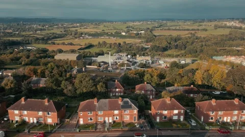 Drone glides over quiet suburban streets lined with red-brick homes Stockbeeldmateriaal 343568023