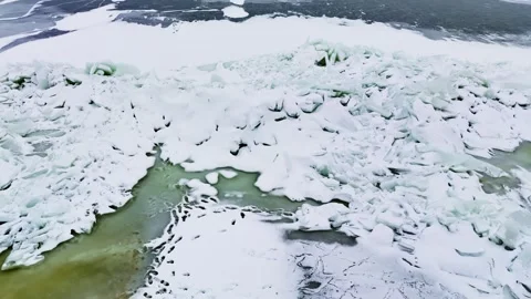 Drone glides over shattered sea ice pressure ridge and turquoise meltwater Stock Footage 331011687
