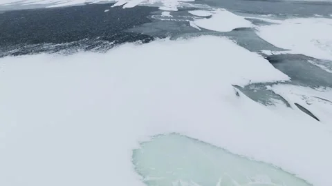 Drone glides over snow-covered pressure ridge and broken floe rubble beside Video stock 332456626