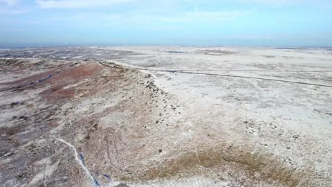 Drone glides over stark, snowy desert hills 動画素材 347265877