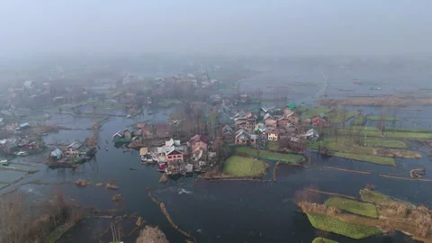Drone gliding low over icy Dal Lake where sunlight sparkles on the frozen Stock Footage 311020575