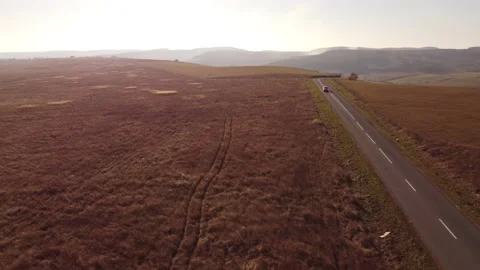 Drone going backwards and following a car coming more and more near, autumn Stock Footage 236291057