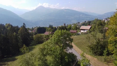 Drone going down hidding a small village and valley behind a tree. Fall Video stock 152129185