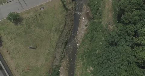 Drone going down in a polluted stream in a poor community Stock Footage 139969137