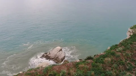 Drone Going Over Cliff with Rocks and Waves Beneath Stock Footage 220804426