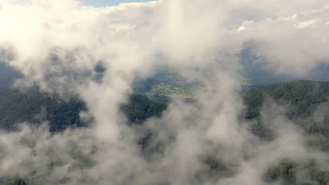 Drone going throw a hole in the clouds in mountains Video stock 263603327