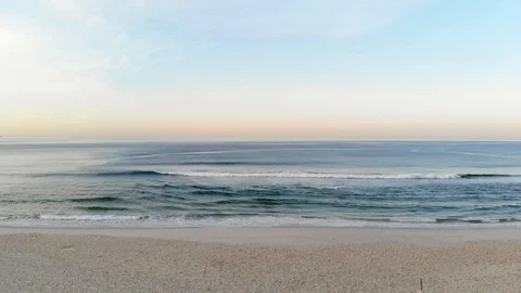 Drone going up while fiming waves crashing on beach during sunrise Stock Footage 89860108