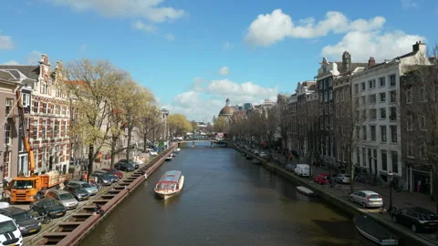 Drone gracefully glides above the captivating river canal in Amsterdam Stock Footage 244444345