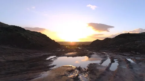 Drone heading toward sunset over mud to reveal lake Stock-Footage 93423012