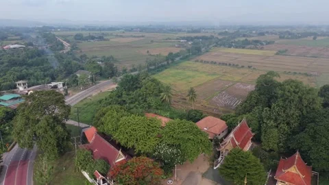 Drone high altitude pull-back shot revealing a Buddhist temple and  rice fields Stock Footage 336297510