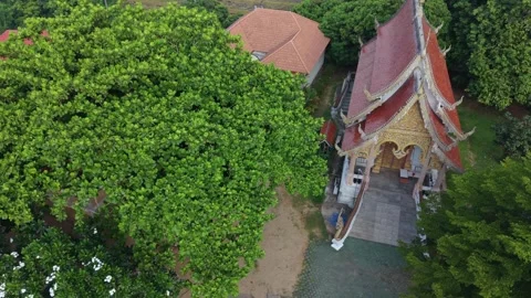 Drone high-angle panning shot over a Buddhist temple revealing a white stupa 스톡 동영상 336297508