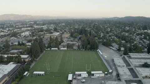Drone high angle shot of american football field surrounded by city Stock Footage 120304203