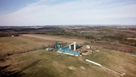 Drone high pullback from quebec dairy farm in spring Stock Footage 93363011