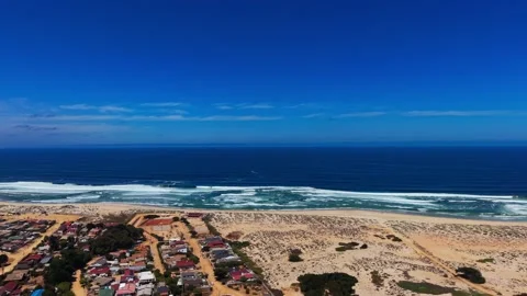 Drone Horizontal Forward Flight over a Coastal Town, Large Sand Dunes and t.. Video stock 339252844
