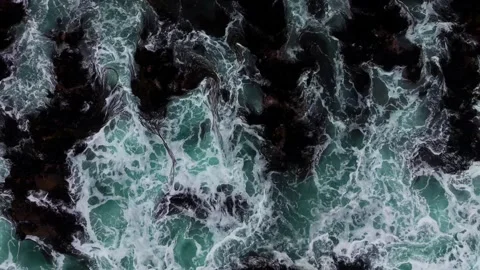 Drone Horizontal Stationary Top Down View of Ocean Waves Crashing on Dark R.. Vídeos de archivo 339253113