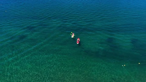 Drone Horizontal Tracking Panoramic View of Paddleboarders on Turquoise Lak.. Stock Footage 339252280