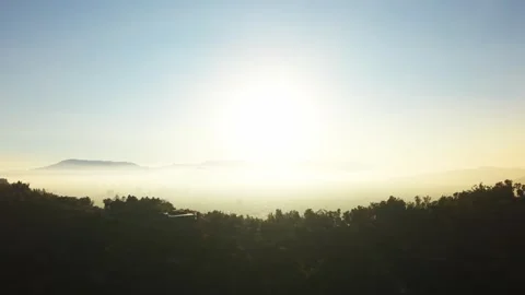 Drone Horizontal Zooming Out View of Sun Rising Over a Polluted Hazy Valley.. Video stock 339254217