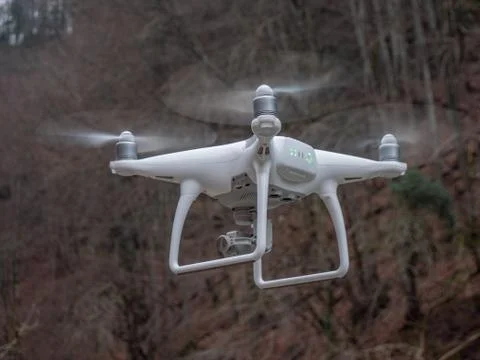 A drone hover in flight in front of the camera with landing lights flashing Stock Photos