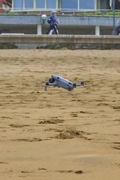 Drone hovering above sandy beach near promenade Stock Photos