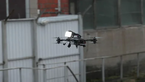 Drone hovering against the wall of an industrial building 動画素材 169398197
