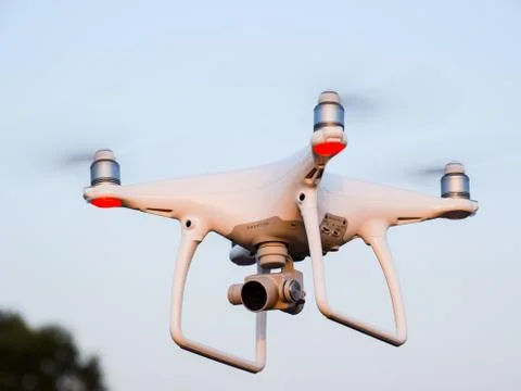 The drone, hovering in the air against the treetops Stock Photos