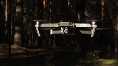 Drone hovering in the air with forest background Stock Footage 134338122